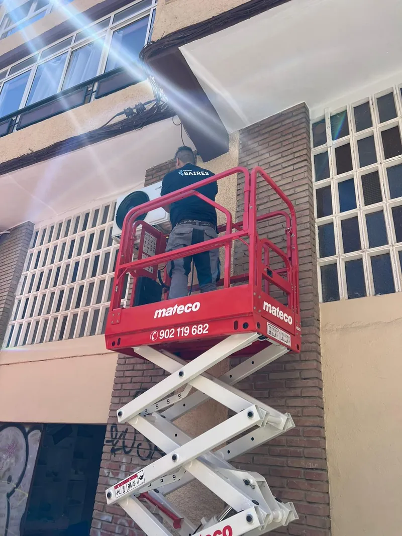 Instalación de una unidad exterior en fachada desde plataforma elevadora: trabajo en altura con equipos de protección